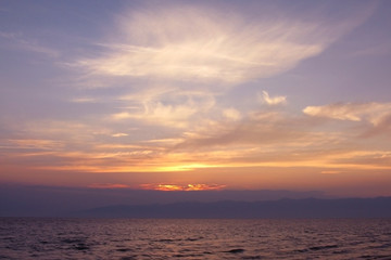 Fototapeta na wymiar The sun sets over the sea, sunset over the pond, quiet evening, blue haze. Calm mood, meditation, peace.