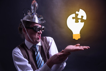 Funny nerd or geek with aluminium hat looking to light bulb having an idea