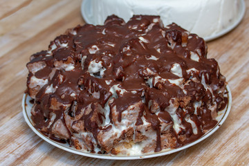 A huge brown and white cake made of pieces