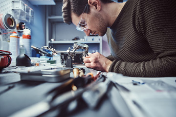 Electronic technician working in the modern repair shop - obrazy, fototapety, plakaty