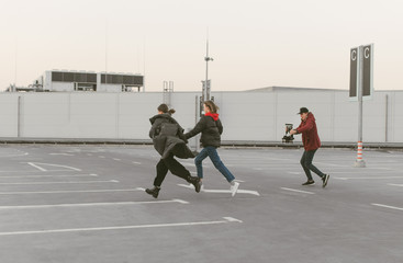 Obraz premium Cameraman shoots videos on the camera with the stabilizer of two girls running along the street. Videographer runs with the stabilizer in his hand and takes video.