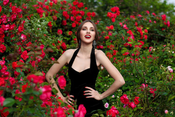 Obraz na płótnie Canvas Portrait of beautiful young woman in the rose garden, spring time, rose flowers blossoms.