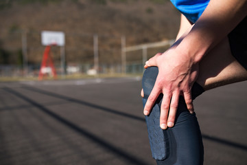 Injured basketball player holding his leg in pain