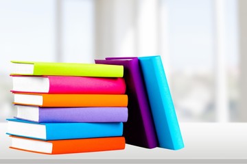 Colorful books collection on background.