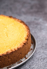 Tasty homemade vegan lemon cheesecake on dark gray stone plate