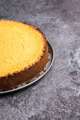 Tasty homemade vegan lemon cheesecake on dark gray stone plate