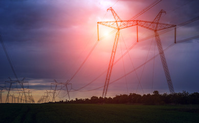  high-voltage power lines at sunset. greeb field.