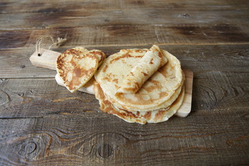 pancakes on a board on a rustic wooden table with space for text