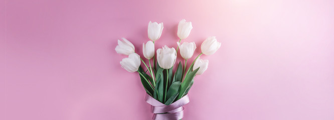 Bouquet of white tulips flowers on pink background. Card for Mothers day, 8 March, Happy Easter. Waiting for spring. Greeting card or wedding invitation. Flat lay, top view