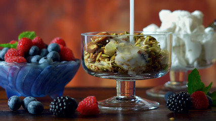 Grain free oat free paleo diet granola breakfast served with fresh seasonal berries, coconut milk, and coconut yoghurt.