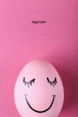 Pink egg with painted smiles. Happy Easter concept greeting card design.