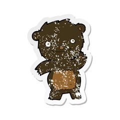 retro distressed sticker of a cartoon waving black bear cub