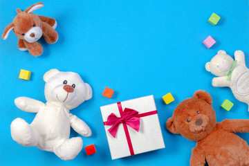 Kids baby toy background. Teddy bears, present gift box and other toys on blue background