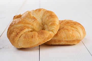 Fresh croissants isolated on wooden table