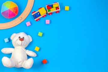 Kids toys background with teddy bear, wooden train and colorful blocks