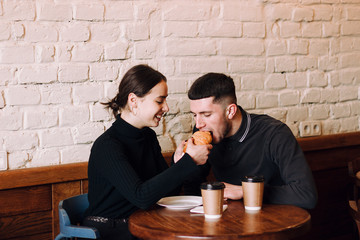Happy loving couple enjoying breakfast in cafe