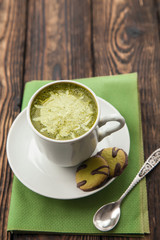 cup of Matcha tea and green cookies on a green napkin