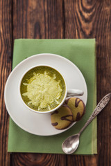 cup of Matcha tea and green cookies on a green napkin