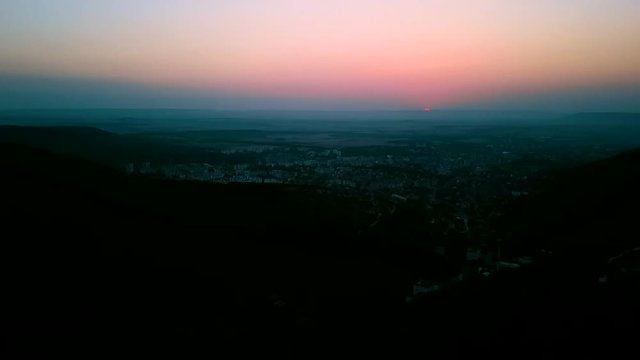 Sun rising up from horizon over city