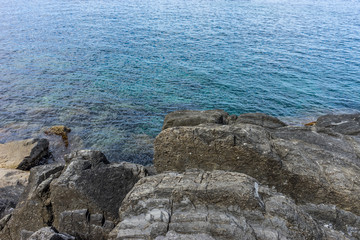 Italy,Cinque Terre,Riomaggiore, a close up of a rock next to a body of water