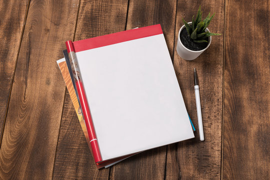 top view image of open notebook with blank pages next to cup of coffee on wooden table. ready for adding text or mockup.