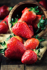 Fresh red strawberry on vintage wooden kitchen table background, rustic style, selective focus