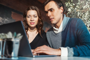 Young man and woman working in front of the laptop. Team meeting,work process.