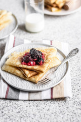 Pancakes with berries and honey on a gray background. Pancake week. Delicious breakfast of pancakes with jam.