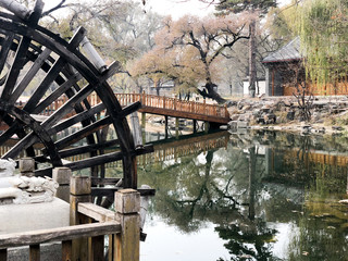 Water mill wheel in a calm little river and little pavilion on the background at The Imperial Summer Palace of The Mountain Resort in Chengde. China.  © Unwind