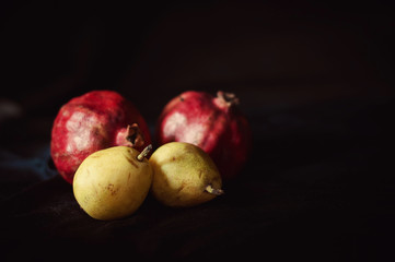 Fototapeta na wymiar pomegranat and pear on black background