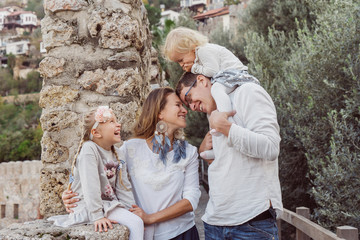 happy family portrait outdoors. parents with two daughter in garden. man, women and kids having fun and laughing.