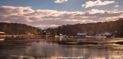 sun on cold day at the lake with wind mill