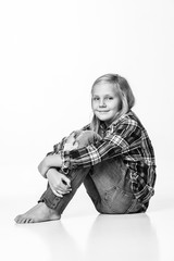 Photo black and white cute girl sitting on the floor and smiling sincerely. White background