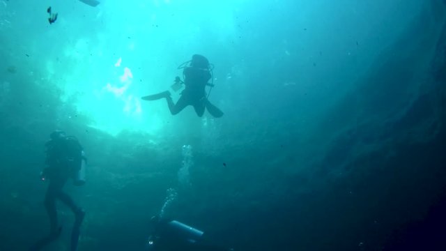 Scuba divers in the Zapotec or Hell's Bells cenote in Mexico.