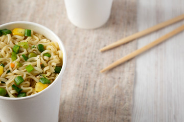 Tasty instant noodles with beef flavoring in paper cups, low angle view. Close-up.