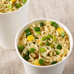 Fastfood: instant noodles with beef flavoring in paper cups, low angle view. Closeup.