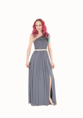 Young woman in a long gray dress standing, smiling