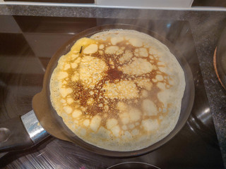 Crepe cooking in a frying pan