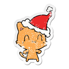 distressed sticker cartoon of a happy cat wearing santa hat