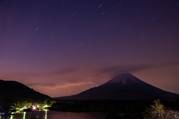 Star trails and Mount Fuji at twilight, the World Heritage, view at Lake Shoji ( Shojiko ). Fuji Five Lake region, Minamitsuru District, Yamanashi prefecture, Japan. Landscape for travel destination.
