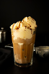 Ice-cream and coffee cocktail in glass. summer, refreshing coffee drink over black background.