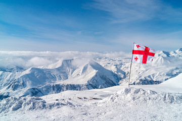 Panoramic view on ski resort Gudauri from Kudebi mountain. High Caucasus Mountains, with Georgia flag.