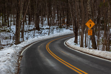 Acton, United States, February 27, 2019. Forest road with double yellow line in winter time, Massachusetts, United States