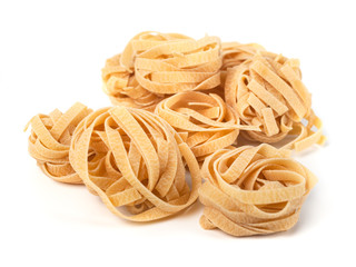 Uncooked nest of tagliatelle Italian pasta isolated on white background