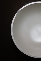 A bowl for kneading the dough with a white bottom is on the table