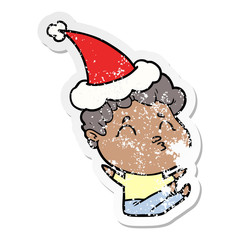 distressed sticker cartoon of a man pouting wearing santa hat