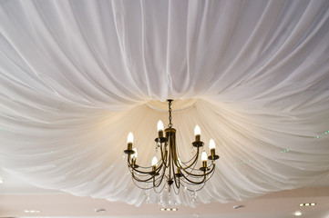 Chandelier draped with white cloth, restaurant