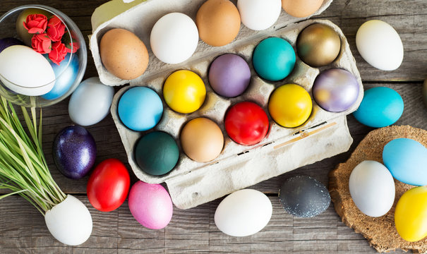 Easter colored eggs in egg tray, young wheat sprouts from the shell, soft focus image 