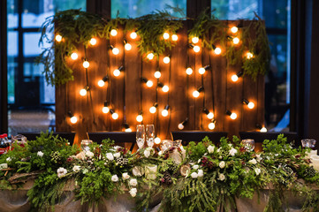 Wedding table decorated with garland of vintage lamps