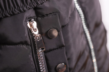 Close up of zipper on black jacket, winter fashion outfit. Jacket isolated on white background.